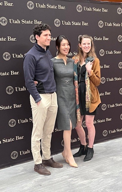 One male and two females stand in front of a Utah State Bar banner after taking the Administration of Attorney Oath at the conclusion of the Admissions Ceremony