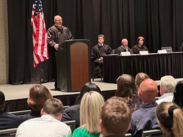 Hon. Jared Bennet stands at a podium giving a speech at the Utah State Bar Admissions Ceremony