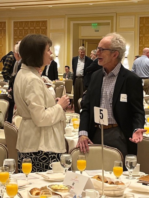 An unidentified female and male family law attorneys talking at the Justice Rising Breakfast