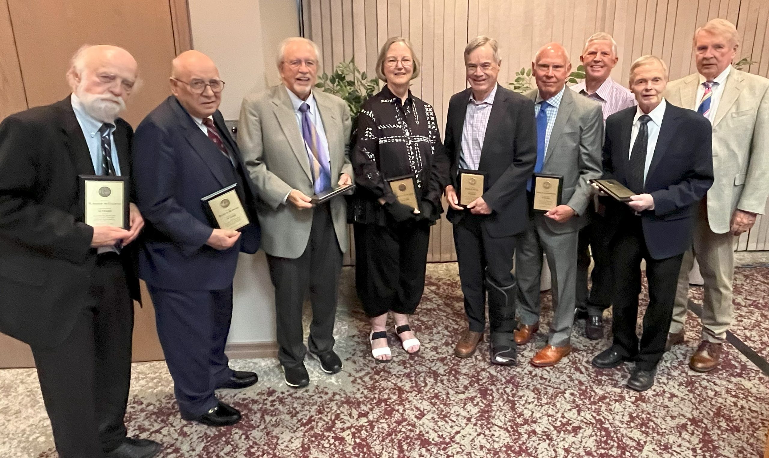 Nine attorneys showing their 50-years-of-service plaques