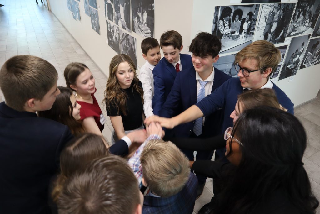 Students participating in mock trial gather in a circle putting their hands in the middle to show their team spirit